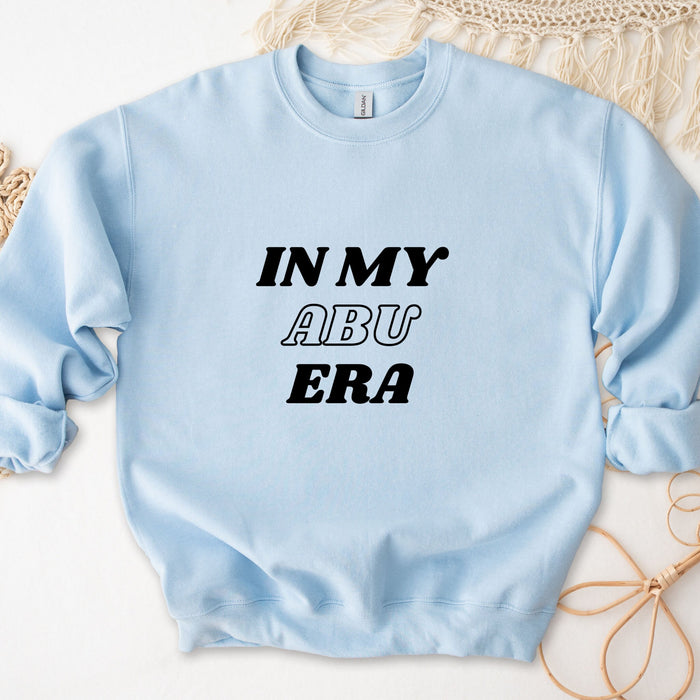 a light blue sweatshirt with the words in my aru era printed on it