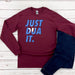 a red shirt that says just dua it next to a pair of jeans