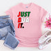 a pink t - shirt that says just dua it next to a pair of